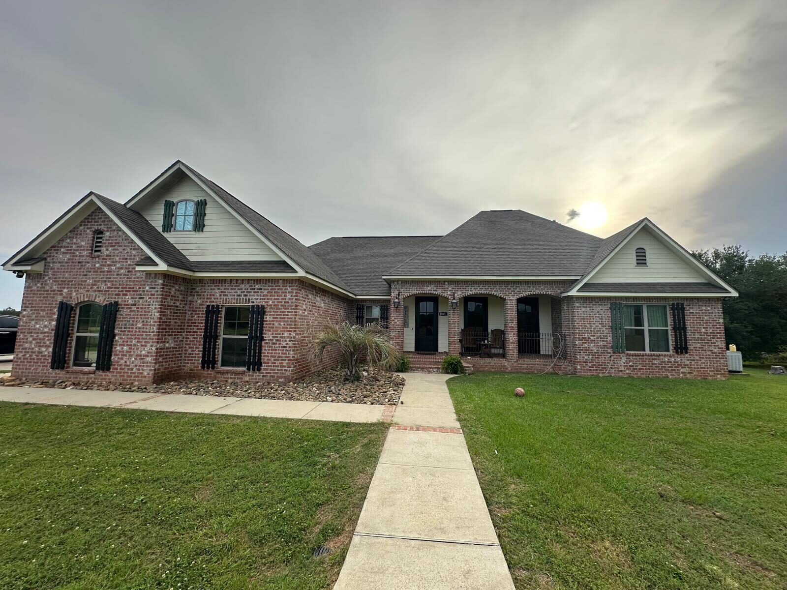 Completed architectural shingle roof on a Louisiana brick home at sunset